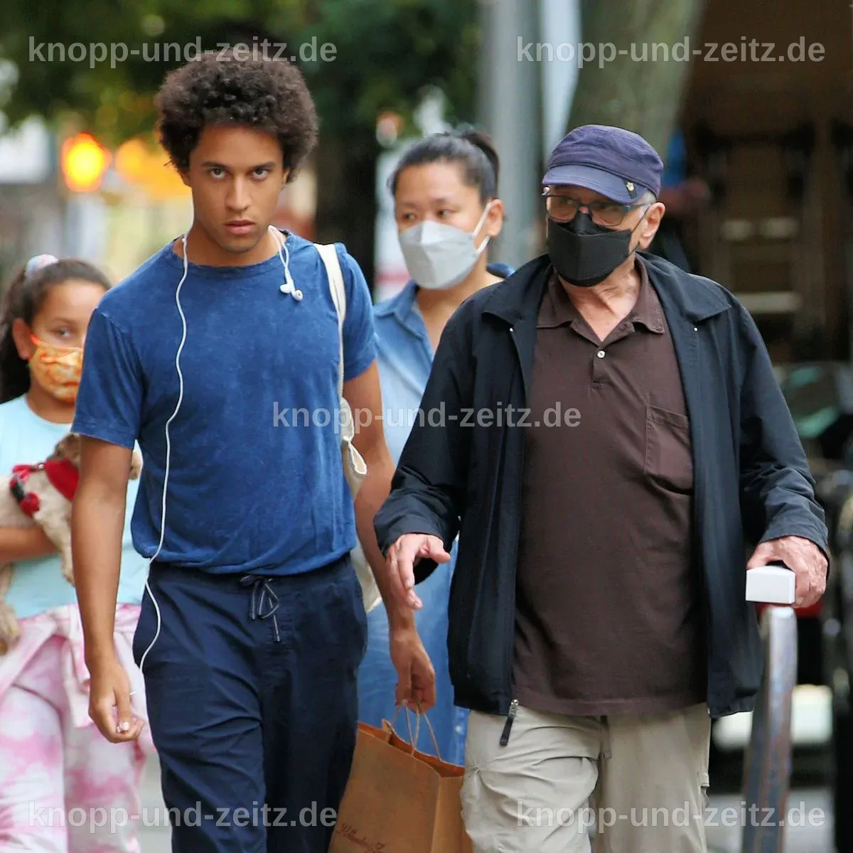 Elliot De Niro sitzt an einem Tisch mit Spielzeug und Lernmaterialien.
