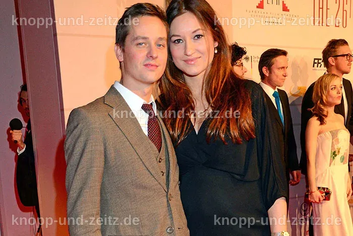Tom Schilling mit seiner Freundin Annie und ihrem Baby im Park.